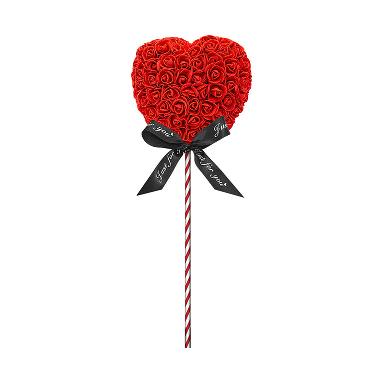 A heart-shaped lollipop with red flowers, standing on a red striped stick, and adorned with a black ribbon reading "Just for you." The perfect gift for anniversaries, birthdays, graduations, Christmas, Valentine's, gender reveal and more. A timeless, romantic gift and a beautiful decoration. The durable nature of the materials make it a lasting memento for any special occasion.
