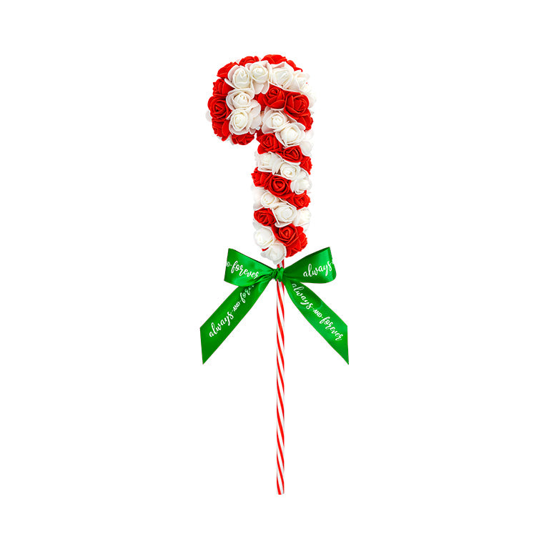 A whimsical candy cane decoration made of spiraling red and white roses, tied with a green bow that whispers sweet nothings like 'forever' and 'love'.