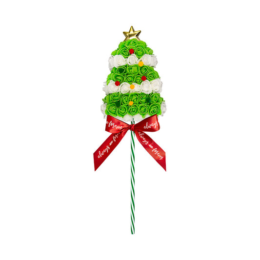 A festive bouquet shaped like a Christmas tree, crafted from green and white roses, topped with a golden star and accented with small red ornaments, all tied with a red ribbon bearing holiday wishes.