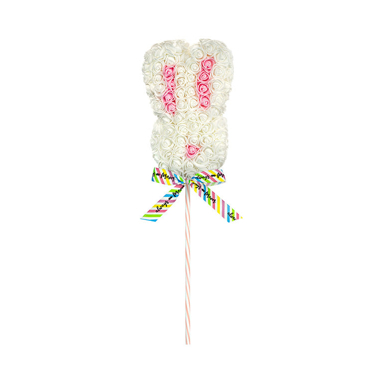 A white floral bunny lollipop with a patterned ribbon on a striped stick, featuring a playful arrangement of roses in a bunny shape.