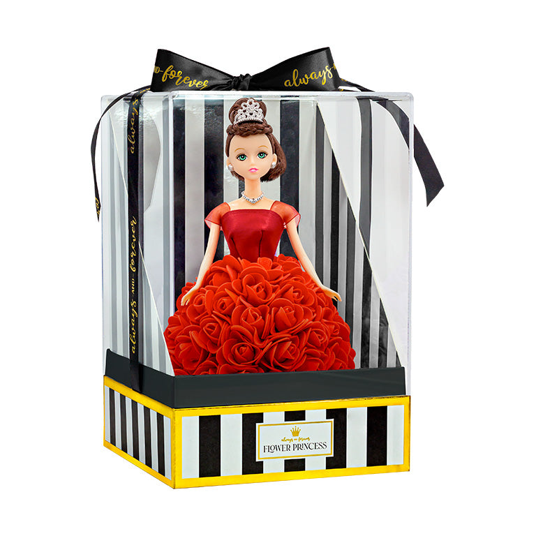 The doll is displayed within packaging, consisting of a clear plastic front against a box with black and white stripes and gold trim. The label "Flower Princess" is affixed to the front. A black ribbon emblazoned with "forever always" is tied in a bow atop the package.