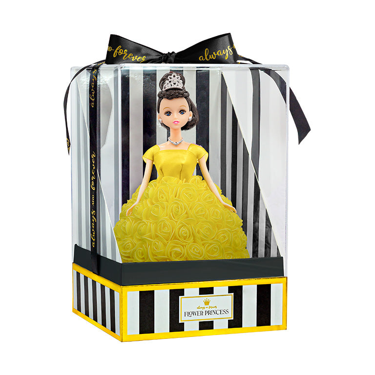 The doll is enclosed in packaging, which comprises a transparent plastic front and a box with black and white stripes, detailed with gold trim. The label "Flower Princess" is placed prominently on the front. A black ribbon with the inscription "forever always" is tied into a bow at the top.