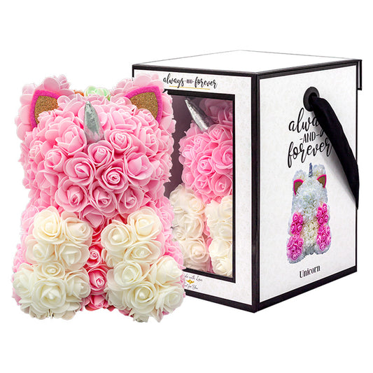 A unicorn shaped product covered in foam roses in the color pink and white. Behind the product is the packaging.