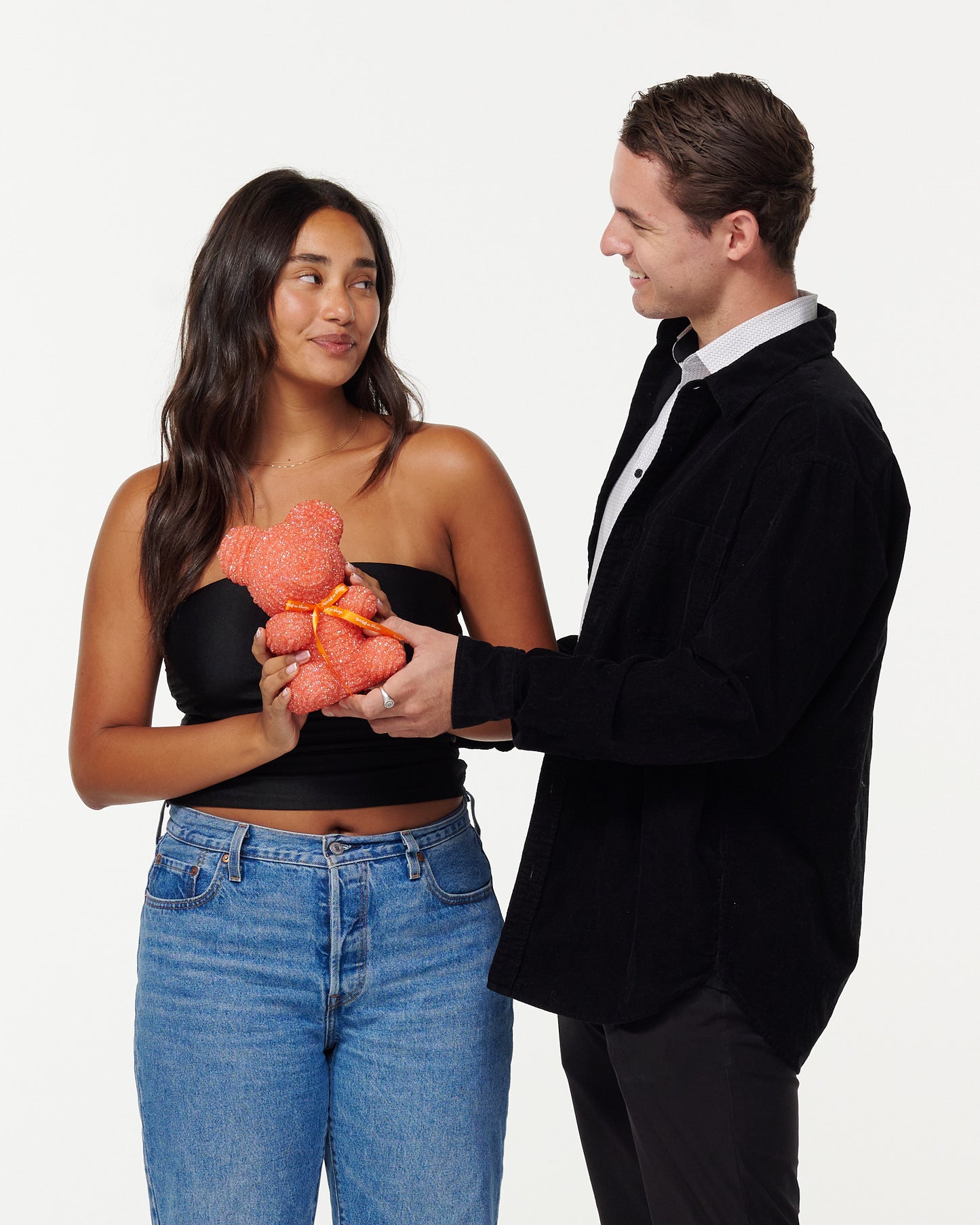 A male model giving a female model the crystal bear product as a gift