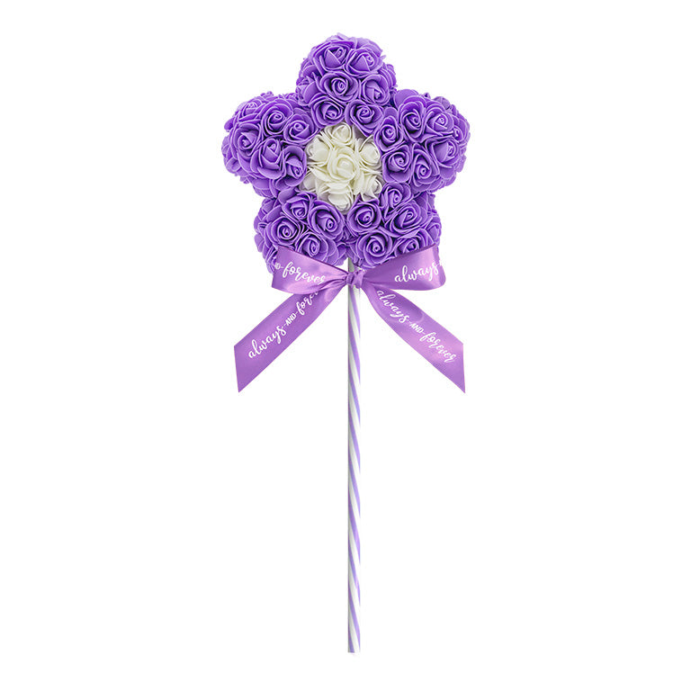 A decorative flower-shaped lollipop, crafted with a purple floral arrangement standing on a purple striped stick, and adorned with a purple ribbon reading "Always and Forever." This piece is perfect for anniversaries, birthdays, graduations, Christmas, Valentine's Day, gender reveal and more. A unique and charming gift idea that can be treasured year-round.
