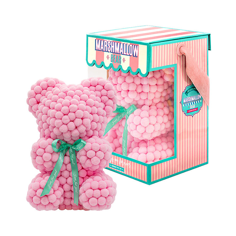 Bear made out of pink-colored faux marshmallows. The bear is adorned with a green ribbon tied into a bow around its neck, and it is packaged in a clear-front gift box with a pink and white striped design. The top of the box features a teal and pink label that reads "MARSHMALLOW BEAR." This delightful creation is an excellent gift idea for various occasions such as anniversaries, birthdays, graduations, Christmas, Valentine's Day, or simply as a unique gift for someone special.	