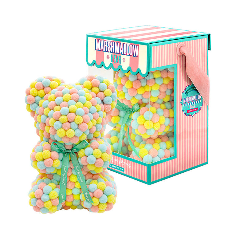 Bear made out of pink, yellow and blue-colored faux marshmallows. The bear is adorned with a green ribbon tied into a bow around its neck, and it is packaged in a clear-front gift box with a pink and white striped design. The top of the box features a teal and pink label that reads "MARSHMALLOW BEAR." This delightful creation is an excellent gift idea for various occasions such as anniversaries, birthdays, graduations, Christmas, Valentine's Day, or simply as a unique gift for someone special.	