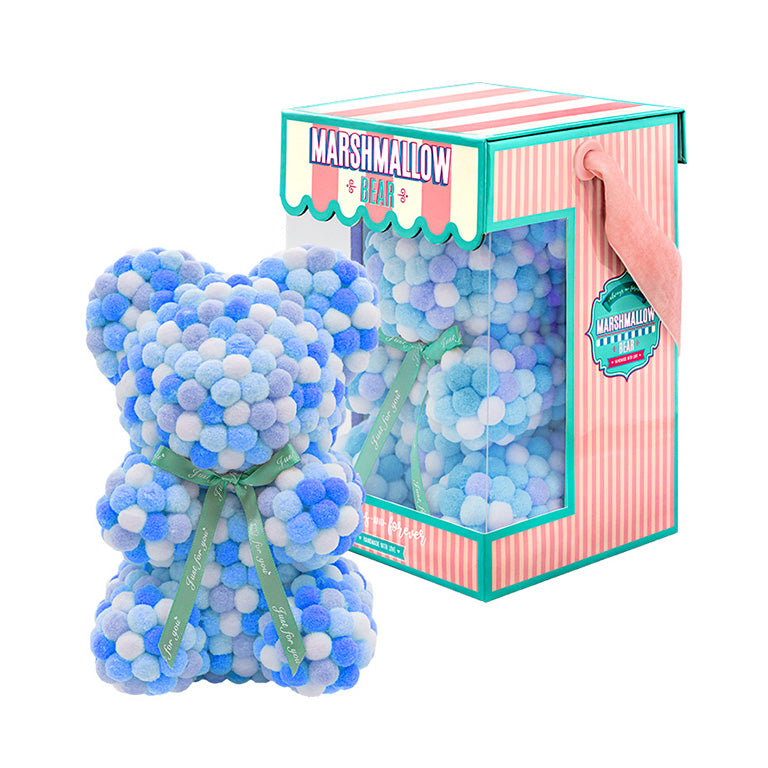 Bear made out of blue hues faux marshmallows. The bear is adorned with a green ribbon tied into a bow around its neck, and it is packaged in a clear-front gift box with a pink and white striped design. The top of the box features a teal and pink label that reads "MARSHMALLOW BEAR." This delightful creation is an excellent gift idea for various occasions such as anniversaries, birthdays, graduations, Christmas, Valentine's Day, or simply as a unique gift for someone special.	