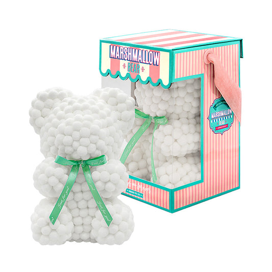 Bear made out of pink, white-colored faux marshmallows. The bear is adorned with a green ribbon tied into a bow around its neck, and it is packaged in a clear-front gift box with a pink and white striped design. The top of the box features a teal and pink label that reads "MARSHMALLOW BEAR." This delightful creation is an excellent gift idea for various occasions such as anniversaries, birthdays, graduations, Christmas, Valentine's Day, or simply as a unique gift for someone special.	