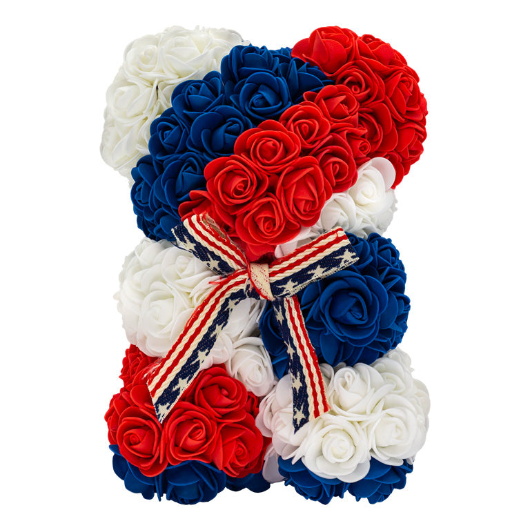 Patriotic bear crafted from red, white, and blue artificial flowers artistically arranged to form a patriotic display, adorned with a stars-and-stripes ribbon symbolizing the American flag. Ideal for national holidays, or as a unique gift to commemorate those who have fought for our country.	