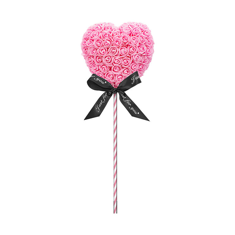 A product designed like a lollipop with the shape of a heart covered in pink foam roses