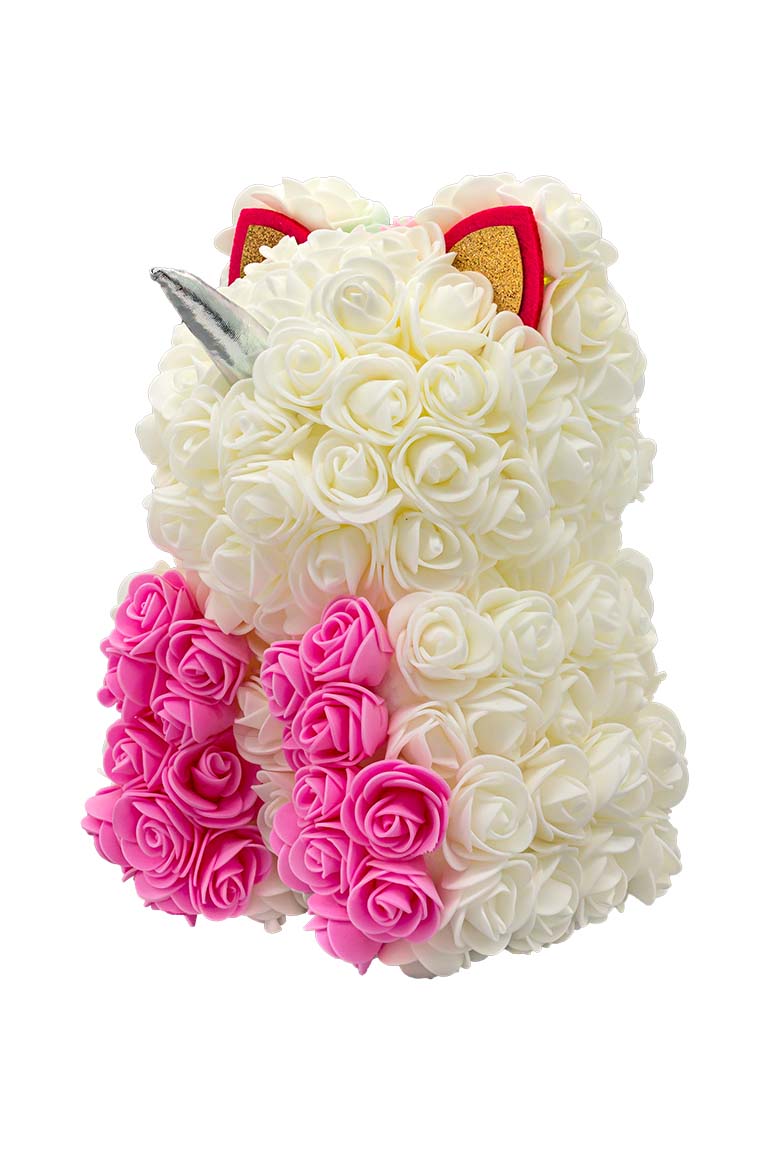 A back view of a unicorn shaped product covered in foam roses in the color white and pink. And a patch of various colors that would be the hair/mane