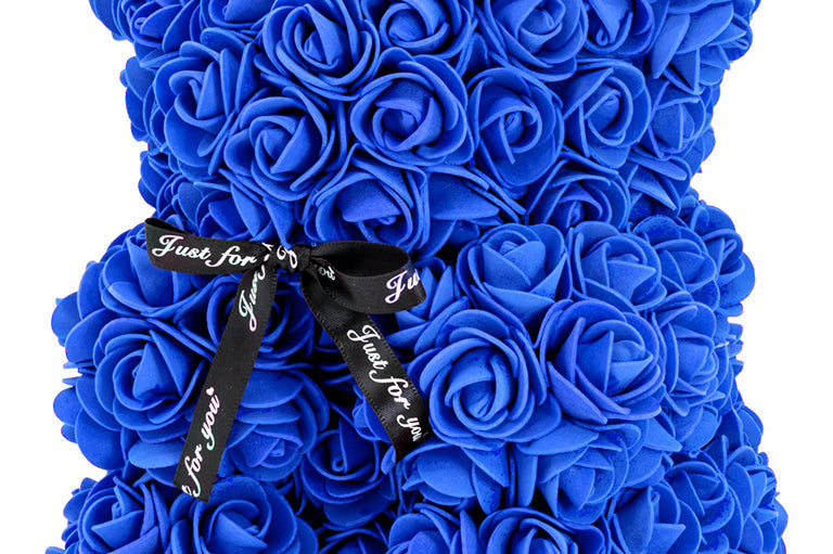 A bear shaped product covered in foam roses in the color navy.
