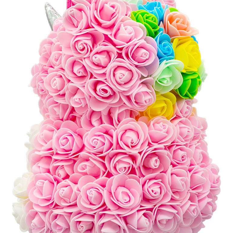 A back view of a unicorn shaped product covered in foam roses in the color pink and white. And a patch of various colors that would be the hair/mane