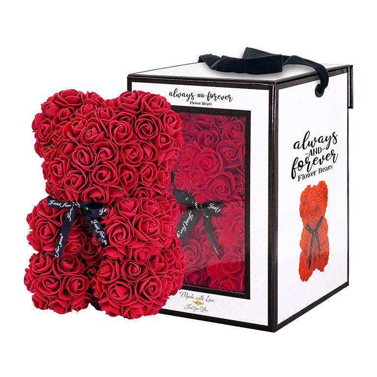 Burgundy, rose-shaped faux bloom bear with a black ribbon around its neck that includes the text "Just for You". The bear is placed next to a stylish white gift box with black accents, which has a clear window. The box comes with a black carrying handle. This intricately crafted floral bear serves as a perfect gift for various occasions such as anniversaries, birthdays, graduations, Christmas, Valentine's Day, or simply as a beautiful decorative item for those special moments.	