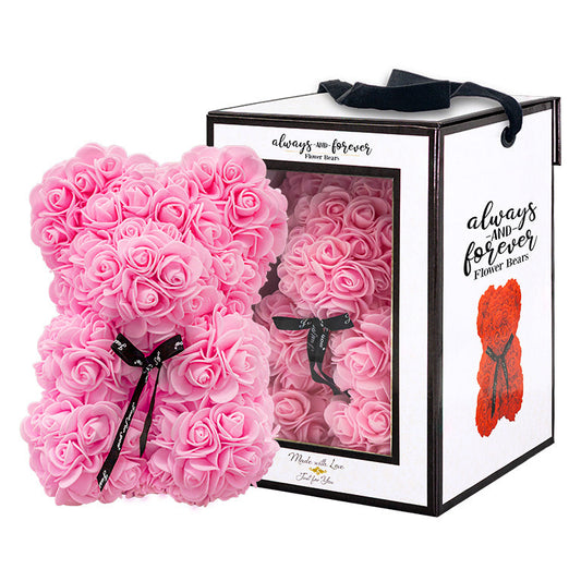 A bear shaped product covered in foam roses in the color of pink. Behind the item is the packaging box of the product.